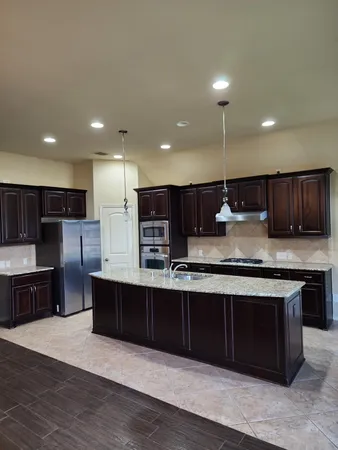a view of kitchen island with stainless steel appliances wooden cabinets and stove