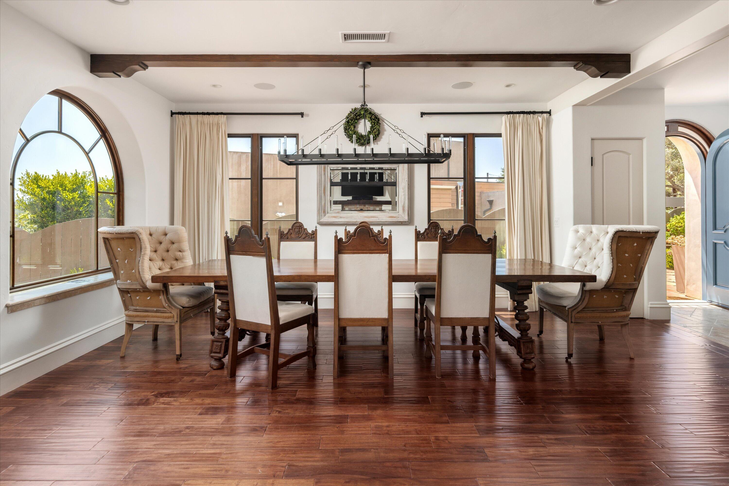 333 Conejo Road Santa Barbara, CA 93103 - Photo 7 of 43 a dining room with wooden floor a chandelier a glass table and chairs