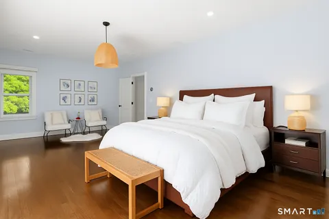 a bedroom with a bed and wooden floor