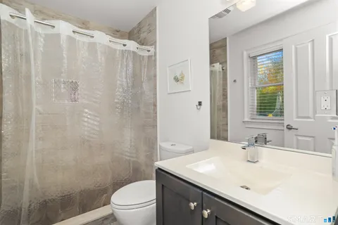 a bathroom with a sink a toilet and shower