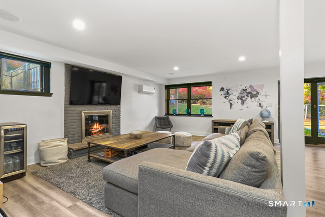 1 Angora Road Westport, CT 06880 - Photo 27 of 39 a living room with furniture a flat screen tv and a fireplace