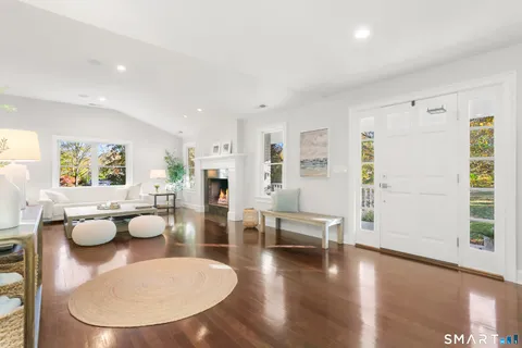 a living room with fireplace furniture and a large window
