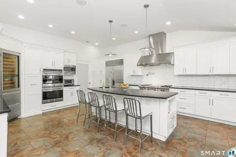 a kitchen with stainless steel appliances granite countertop a sink a stove a microwave a center island and cabinets