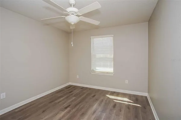 an empty room with a window and a fan
