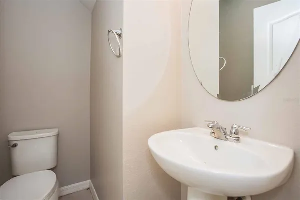 a bathroom with a sink and mirror with toilet