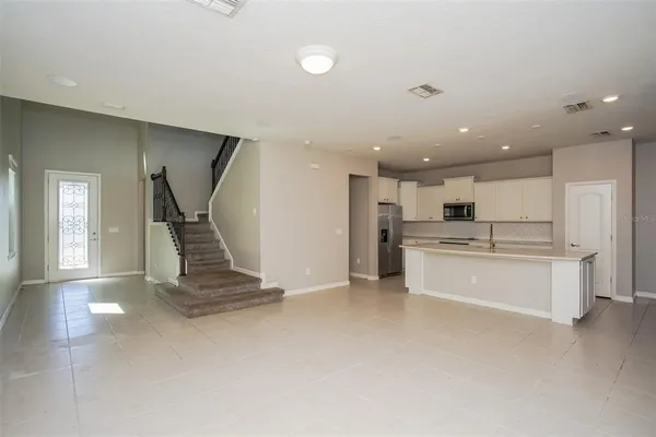 a large kitchen with kitchen island a sink a stove a refrigerator and white cabinets