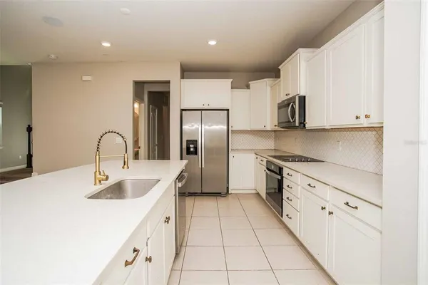 a kitchen with stainless steel appliances granite countertop a sink a stove and a refrigerator