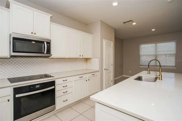 a kitchen with white cabinets stainless steel appliances and sink