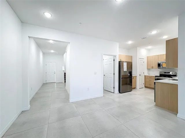 a big room with stainless steel appliances kitchen island granite countertop a refrigerator and a stove top oven