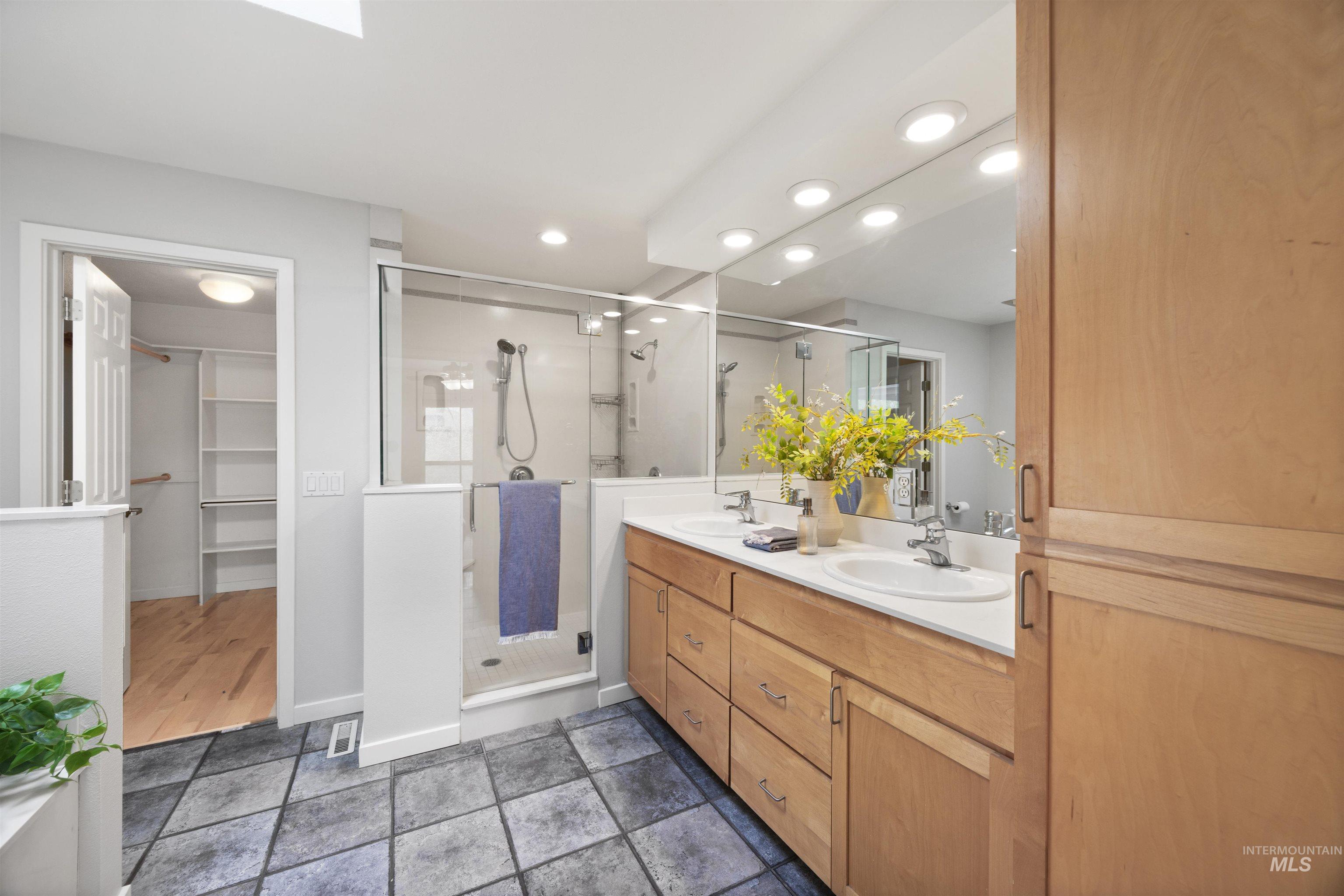 1313 Martin Street Boise, ID 83706 - Photo 13 of 46 Bathroom with a spacious closet, double vanity, recessed lighting, a shower stall, and dark stone finish floors