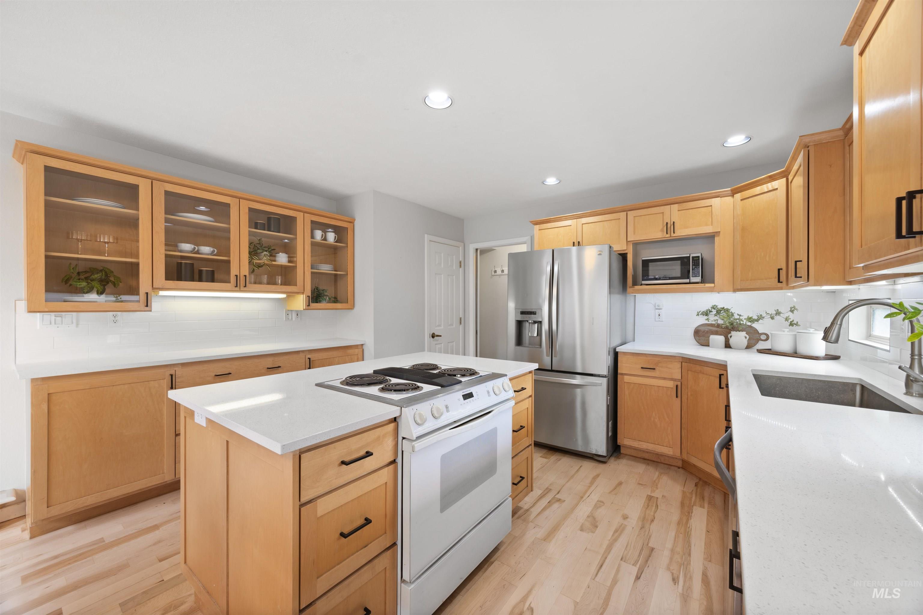 1313 Martin Street Boise, ID 83706 - Photo 25 of 46 Kitchen with stainless steel appliances, glass insert cabinets, decorative backsplash, a kitchen island, and recessed lighting