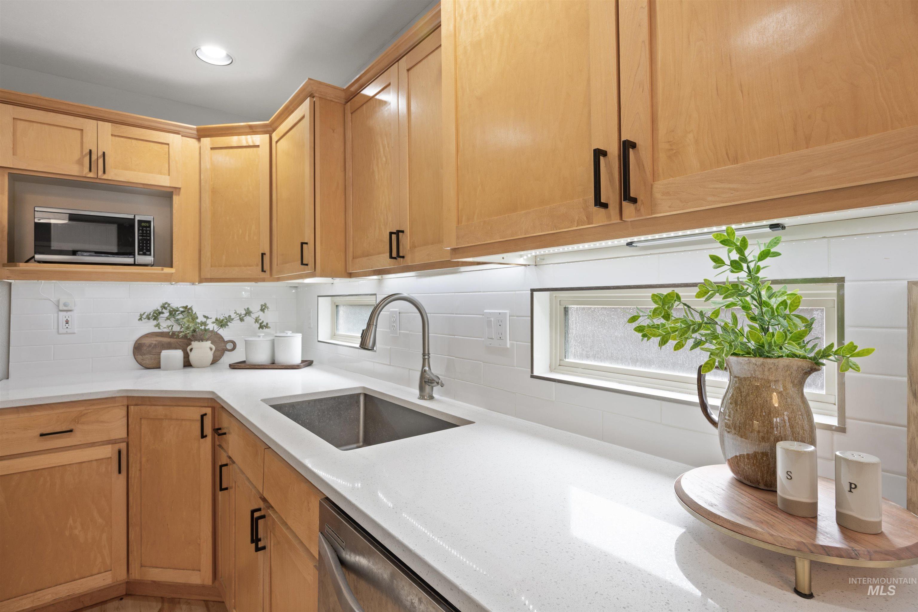 1313 Martin Street Boise, ID 83706 - Photo 27 of 46 Kitchen featuring stainless steel appliances, light stone countertops, and tasteful backsplash