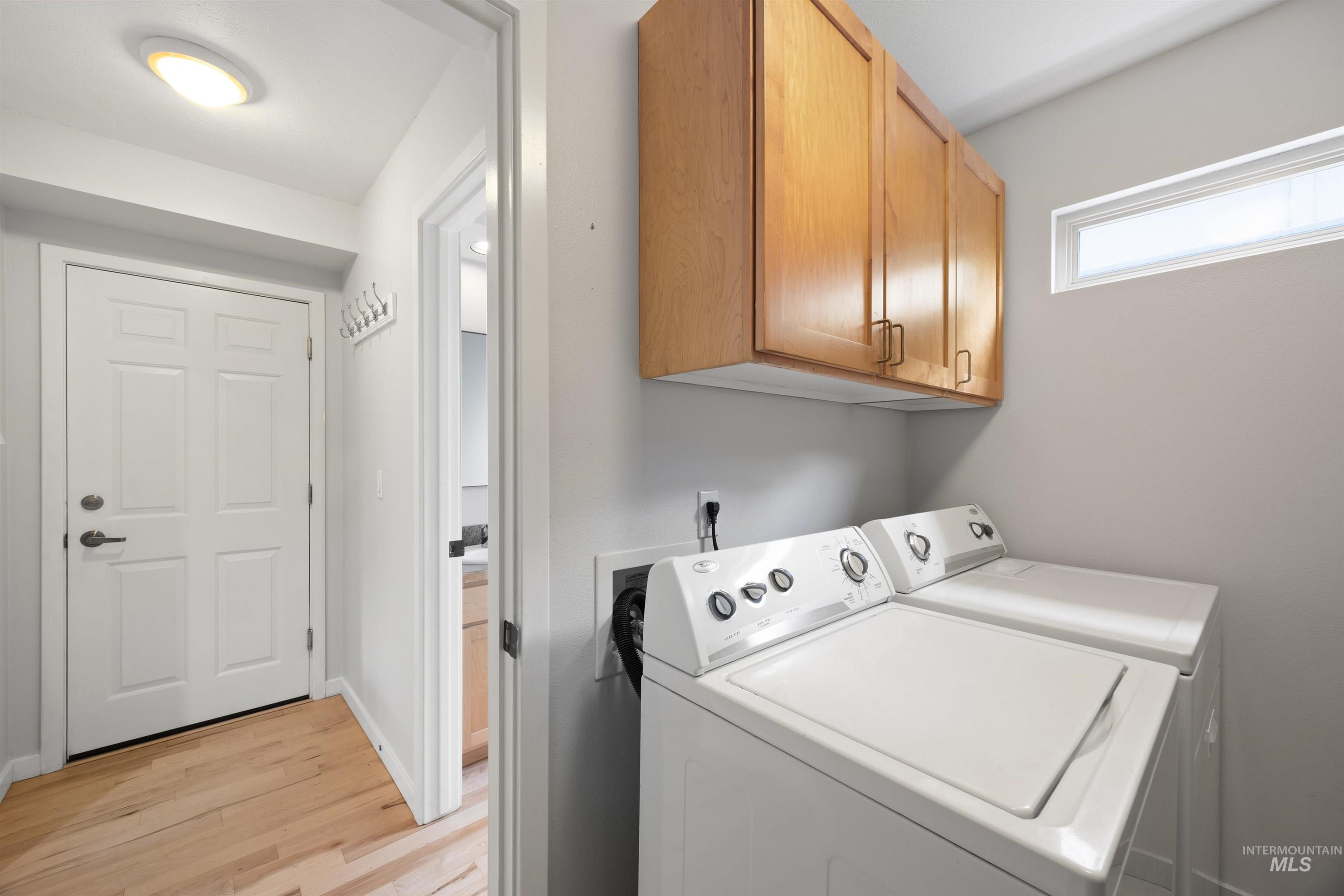 1313 Martin Street Boise, ID 83706 - Photo 36 of 46 Laundry area featuring cabinet space, light wood-style flooring, and washer and clothes dryer