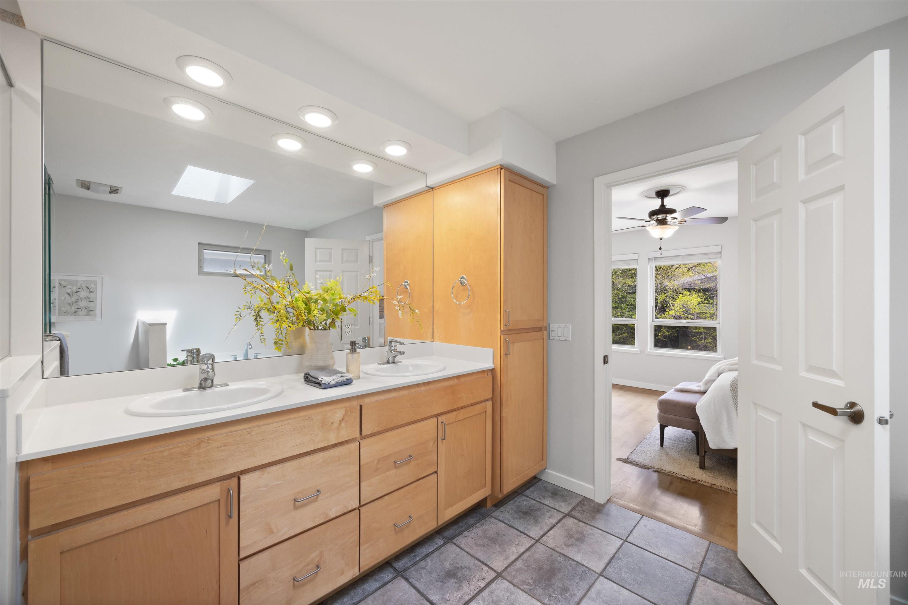 1313 Martin Street Boise, ID 83706 - Photo 39 of 46 Bathroom with double vanity, ensuite bathroom, recessed lighting, a skylight, and dark tile patterned flooring