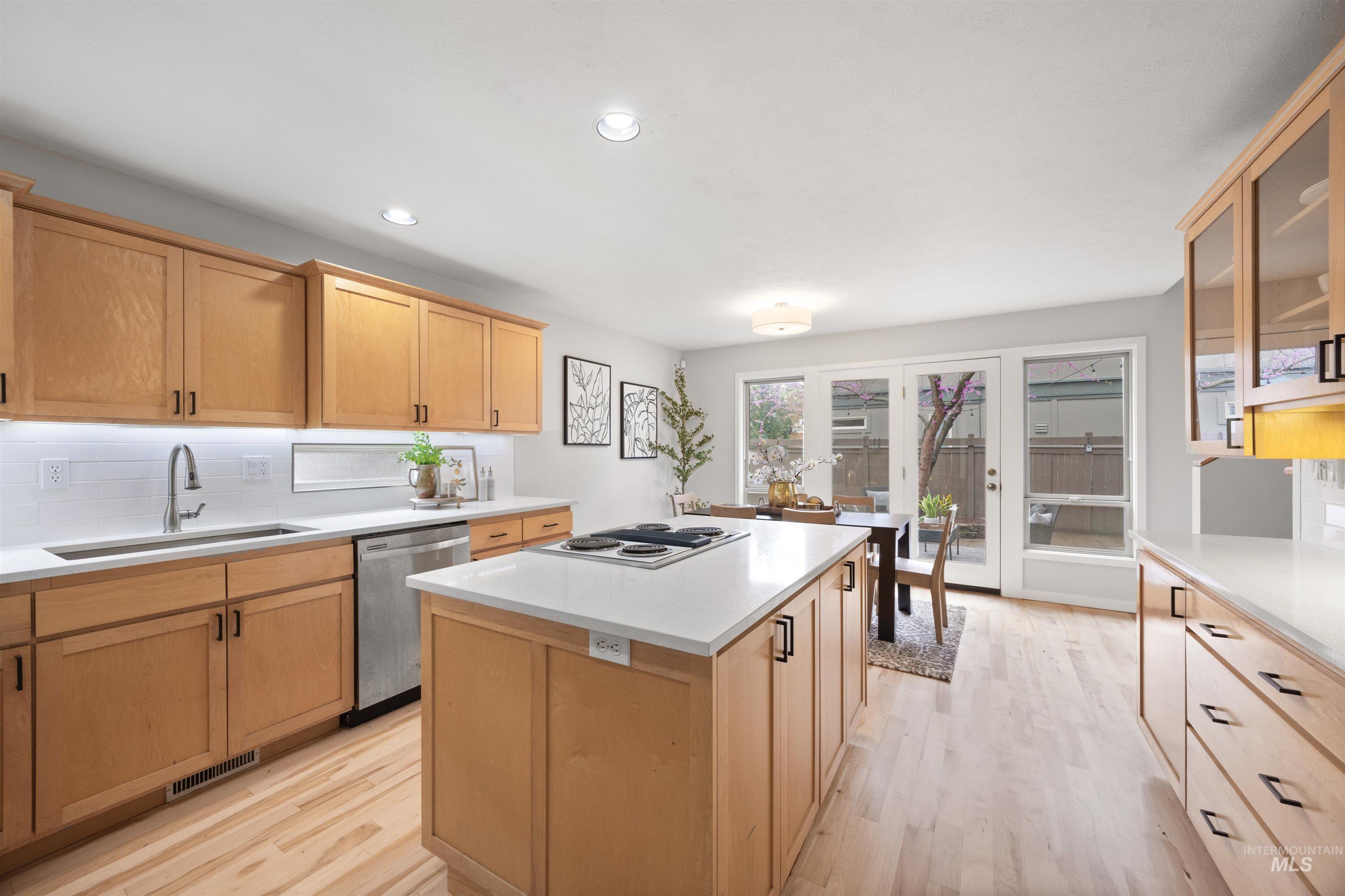 1313 Martin Street Boise, ID 83706 - Photo 7 of 46 Kitchen with a center island, stainless steel appliances, light wood-type flooring, glass fronted cabinets, and recessed lighting