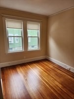 34 Averton Street, Unit 1 Boston, MA 02131 - Photo 12 of 16 an empty room with wooden floor and windows