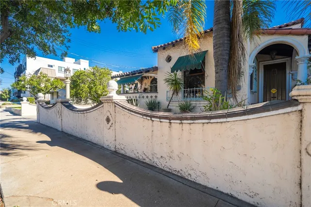 a view of a small house with a tub and potted plants