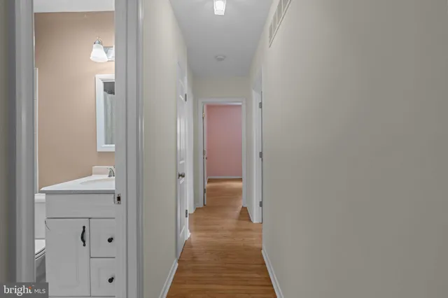 a view of a hallway with wooden floor