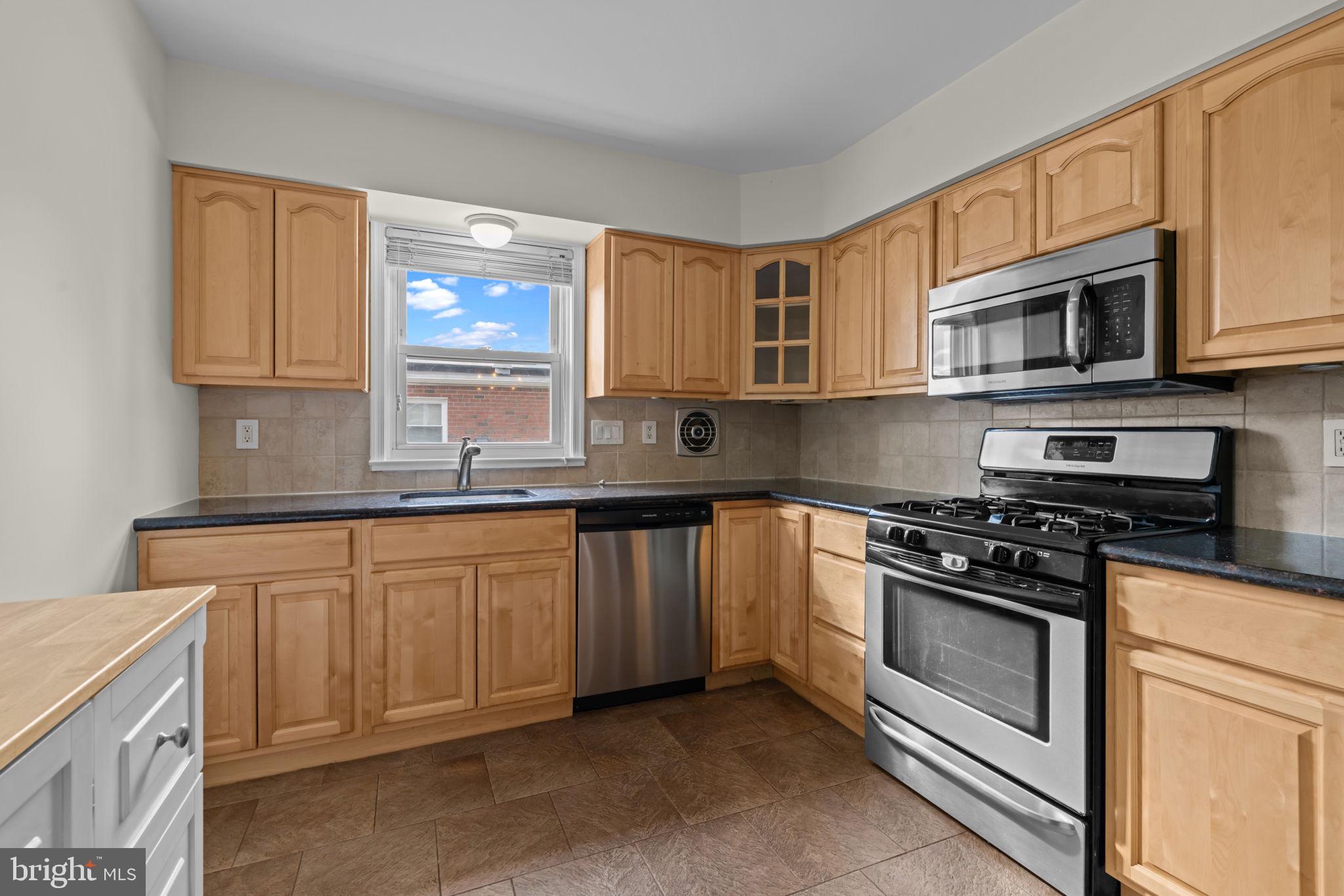 13039 Stevens Road Philadelphia, PA 19116 - Photo 7 of 32 a kitchen with stainless steel appliances granite countertop a stove sink microwave and cabinets