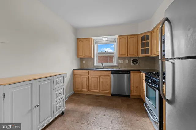 a kitchen with stainless steel appliances a refrigerator sink and stove