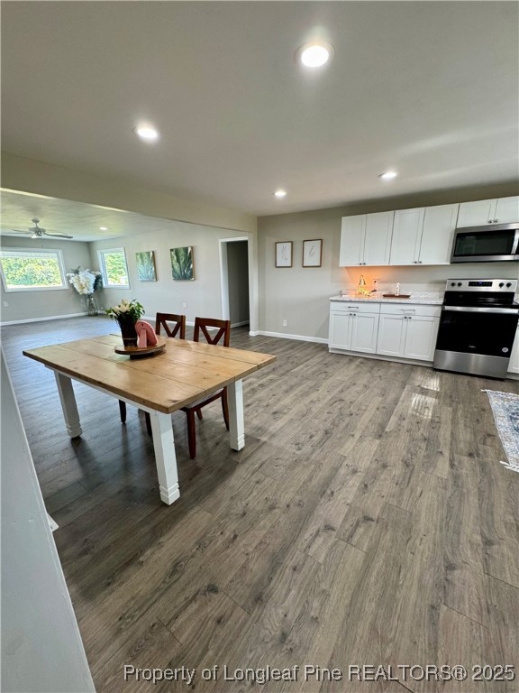 1283 Bethel Baptist Road Spring Lake, NC 28390 - Photo 9 of 44 a kitchen with stainless steel appliances granite countertop a stove a refrigerator a sink a dining table and chairs with wooden floor