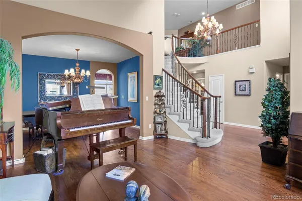 a dining room with furniture potted plants and wooden floor