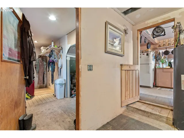 a view of hallway with furniture and a refrigerator