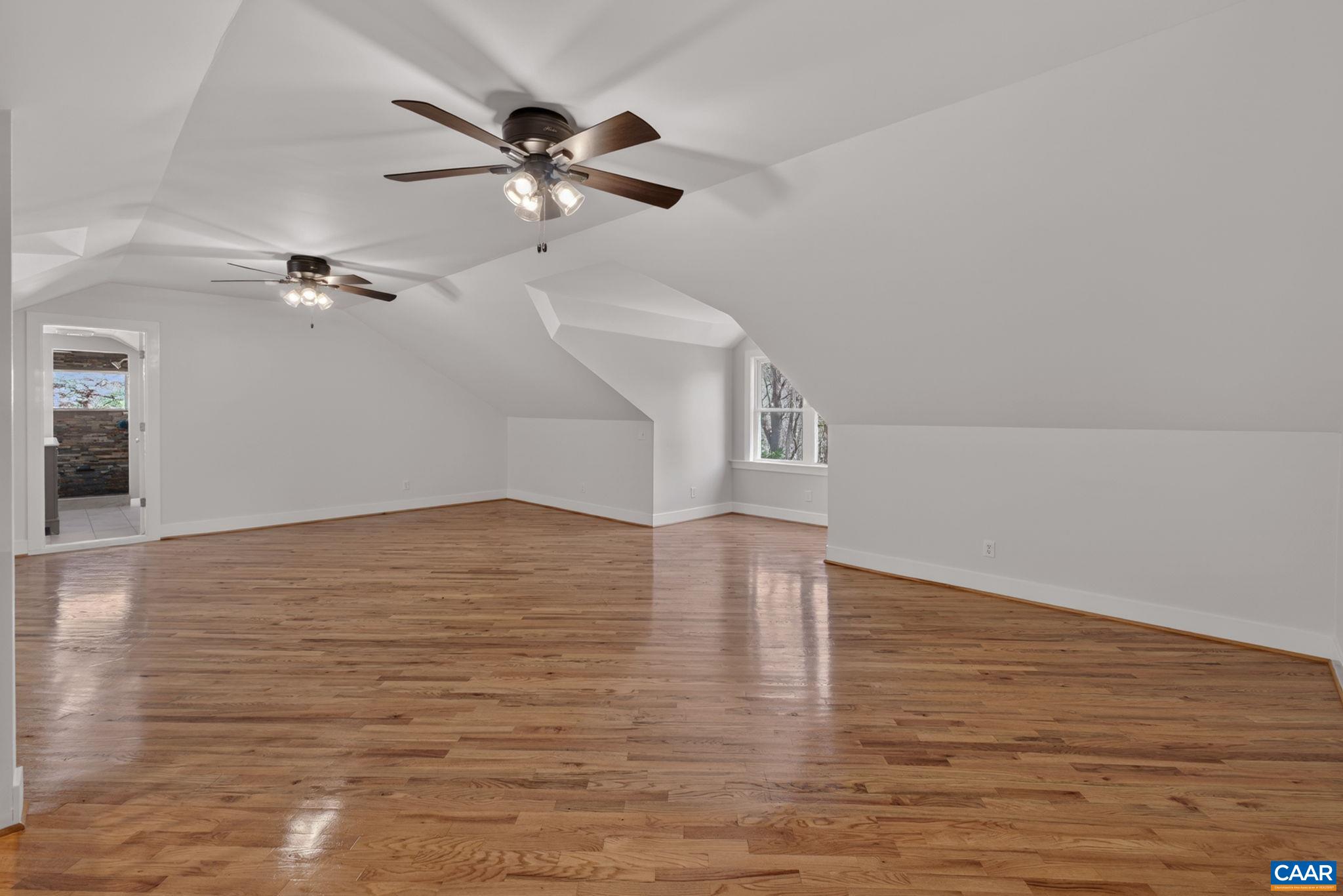 689 Mutton Hollow Road Stanardsville, VA 22973 - Photo 52 of 61 a view of a room with wooden floor a ceiling fan and staircase
