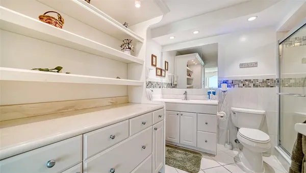a bathroom with a toilet sink vanity and shower