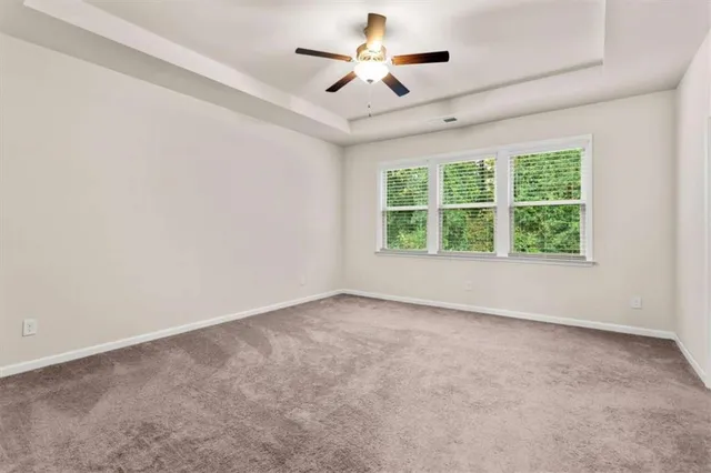 an empty room with a window and a ceiling fan