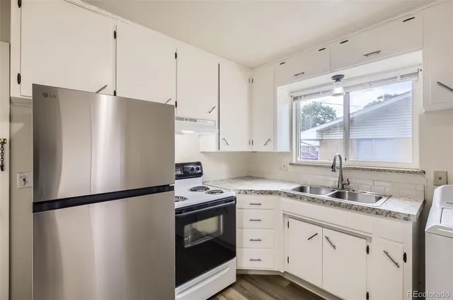 a kitchen with a sink a refrigerator and cabinets
