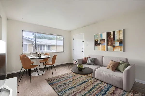 a living room with furniture wooden floor and a window