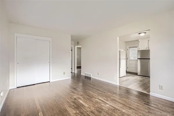 a view of empty room with wooden floor