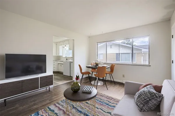 a living room with furniture a flat screen tv and a window