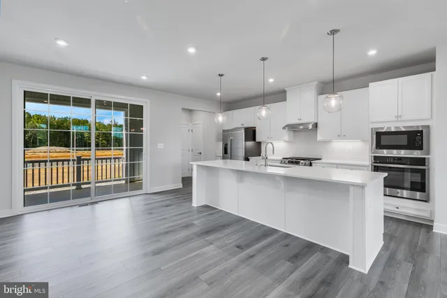 a view of kitchen with cabinets stainless steel appliances with wooden floor