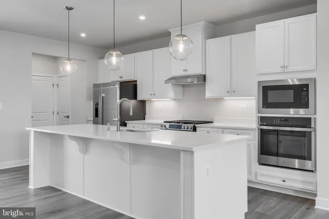 a large white kitchen with large white kitchen appliances and cabinets