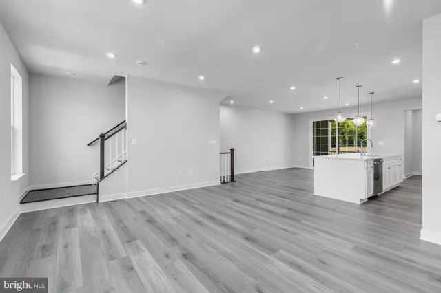 a large kitchen with stainless steel appliances granite countertop a large center island attached withe living room