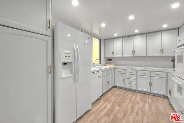 a kitchen with stainless steel appliances granite countertop a refrigerator and window