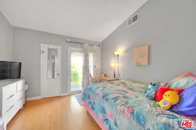 a view of a white house next to a yard with potted plants