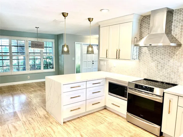 a kitchen with a stove oven and a large window