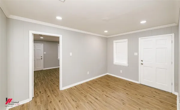 a view of empty room with wooden floor