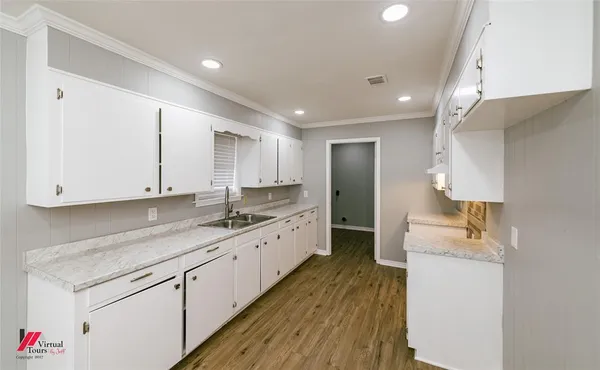 a large kitchen with granite countertop a sink stainless steel appliances and cabinets