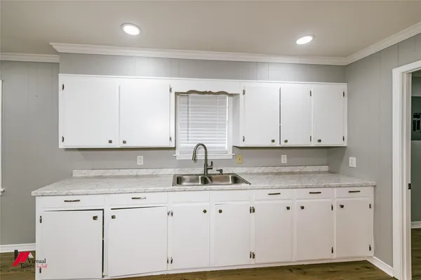 a kitchen with granite countertop white cabinets and sink