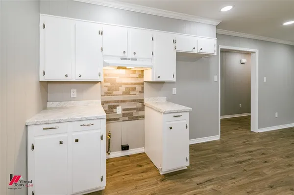 a kitchen with white cabinets and refrigerator