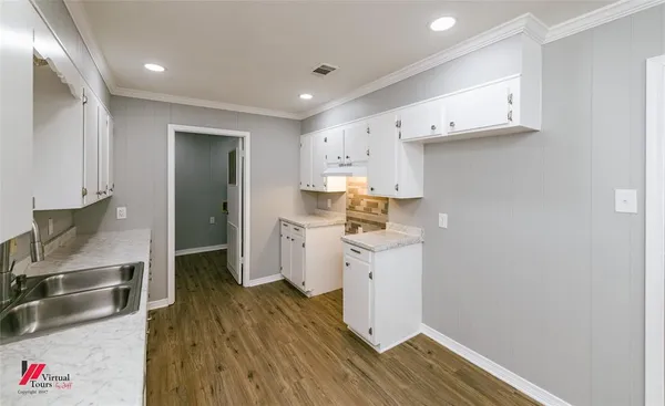 a kitchen with a sink a stove a refrigerator and a cabinets