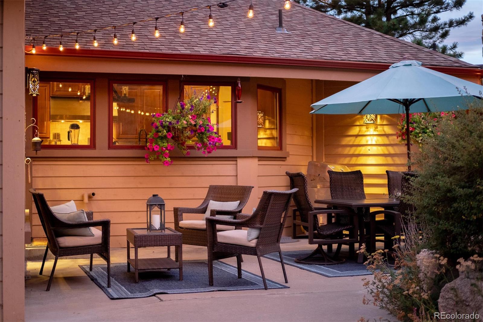 497 Meadow Vista Drive Evergreen, CO 80439 - Photo 15 of 40 a view of a patio with table and chairs under an umbrella