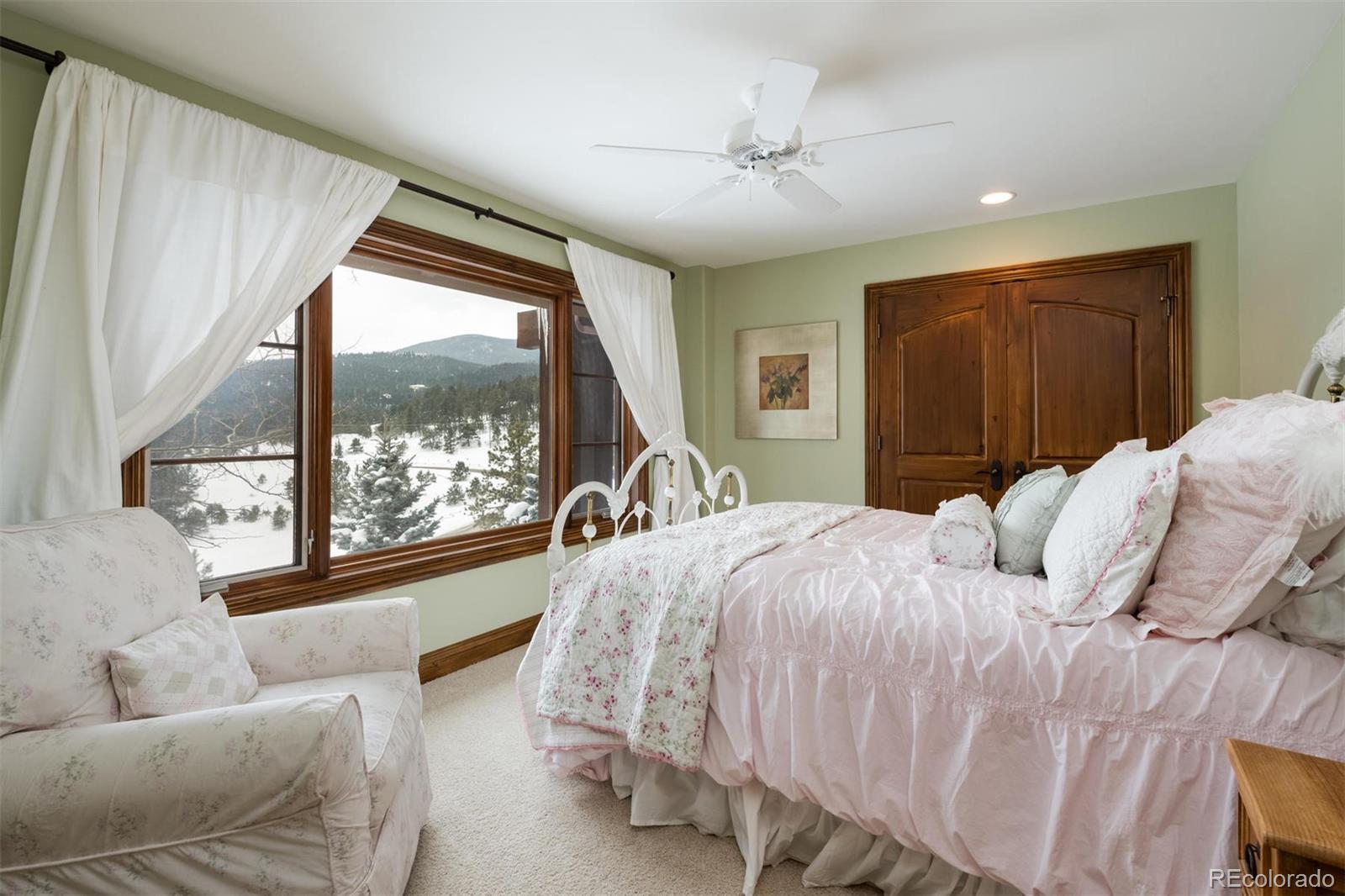 497 Meadow Vista Drive Evergreen, CO 80439 - Photo 26 of 40 a bed sitting in a bedroom next to a window