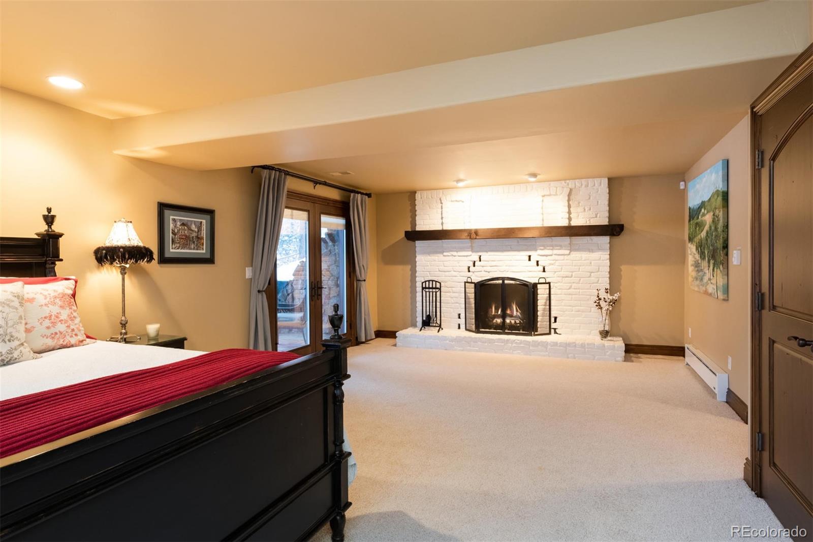 497 Meadow Vista Drive Evergreen, CO 80439 - Photo 30 of 40 a bedroom with a bed and a fireplace