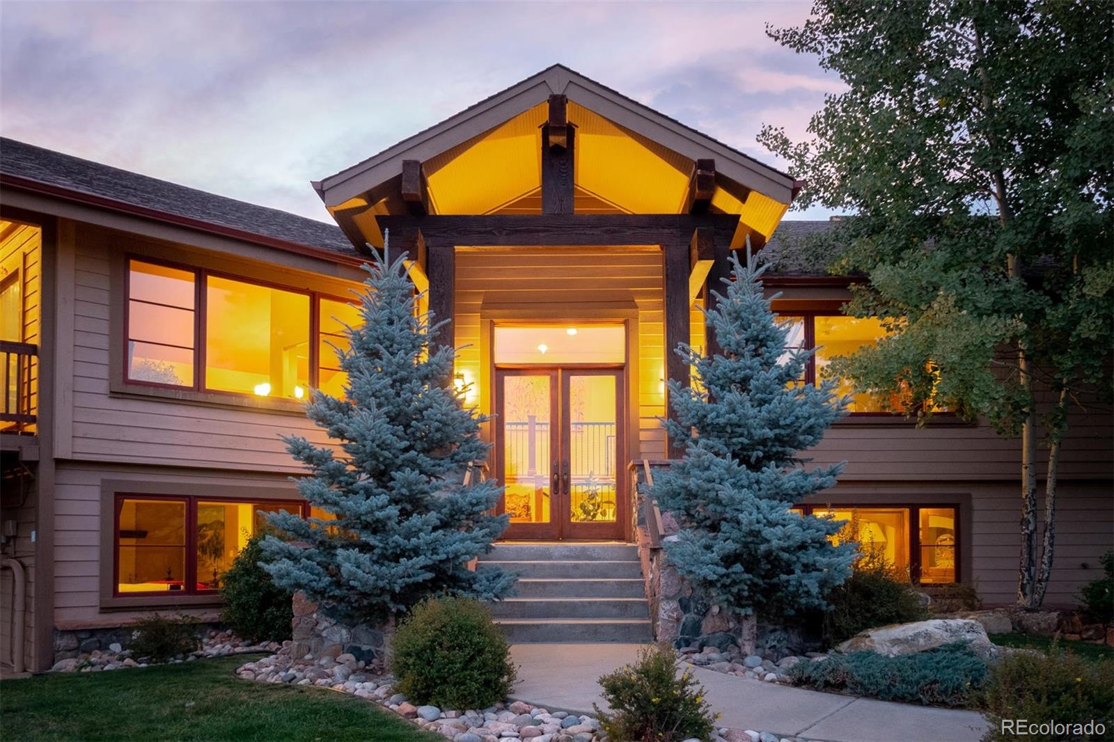 497 Meadow Vista Drive Evergreen, CO 80439 - Photo 3 of 40 a view of a house with a large windows and a yard and plants