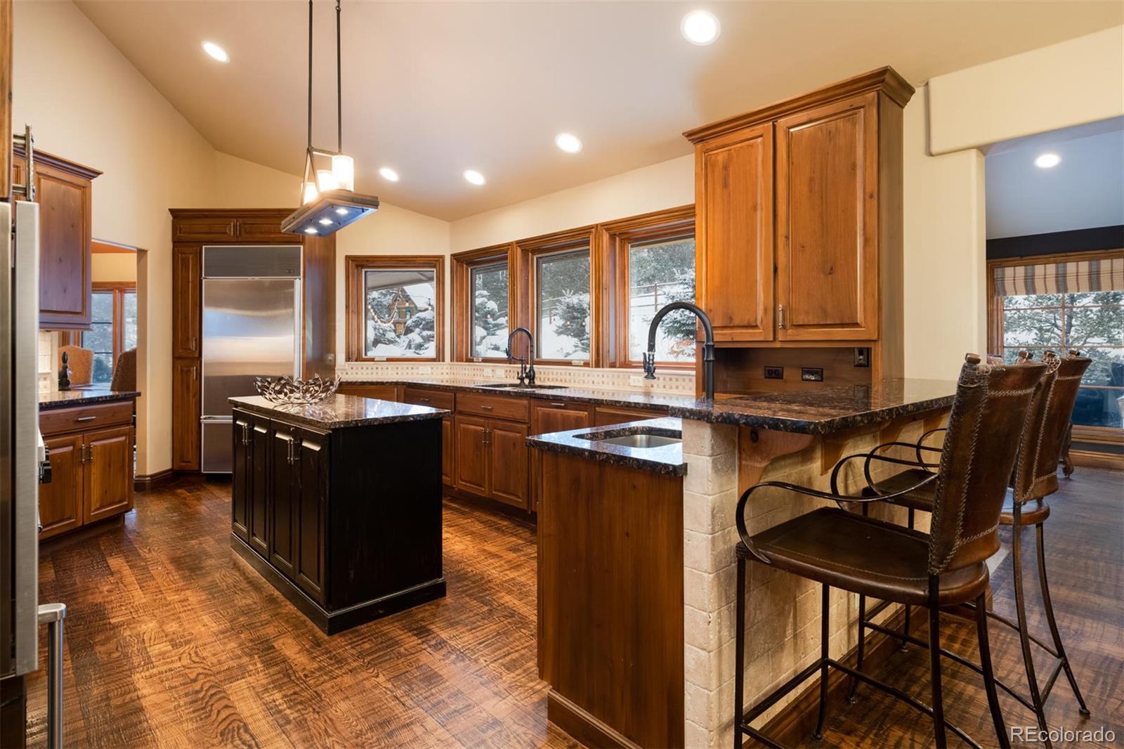 497 Meadow Vista Drive Evergreen, CO 80439 - Photo 10 of 40 a kitchen with stainless steel appliances granite countertop a stove top oven a sink dishwasher a dining table and chairs with wooden floor